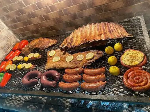 Chorizos, costillas y limones en la parrilla de Mica